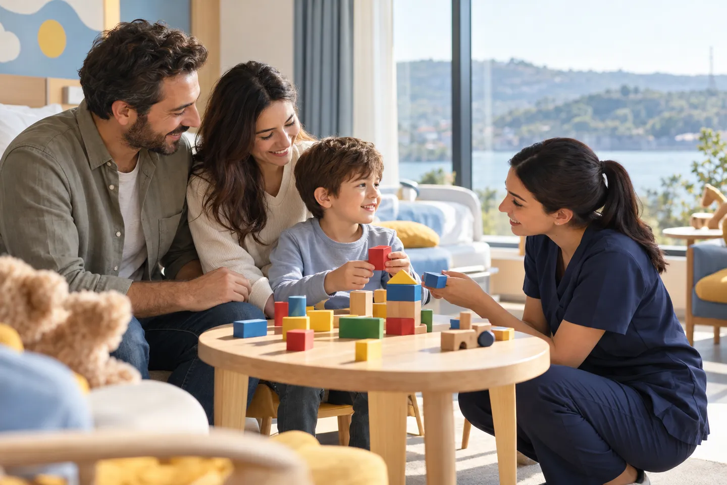 A smiling boy builds with colourful blocks next to his parents while a nurse plays with him in a bright Istanbul clinic room overlooking the water